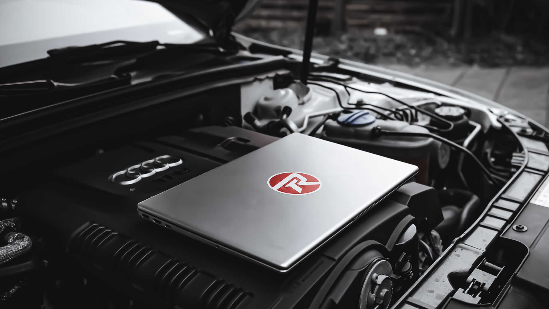 Laptop placerad i motorrum inför tuningjobb